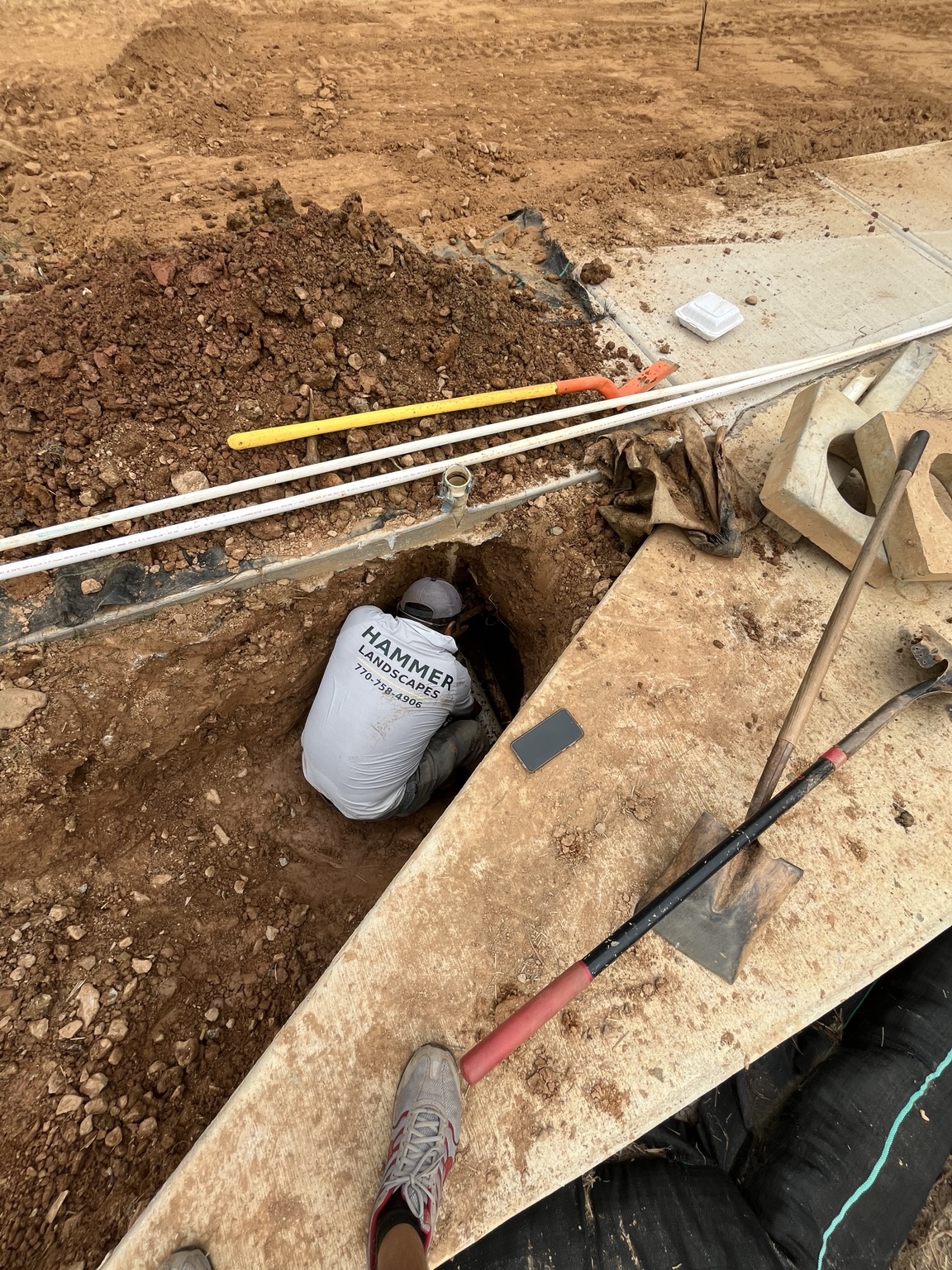 Uncovering the sleeve ends beside the sidewalk and ramp.